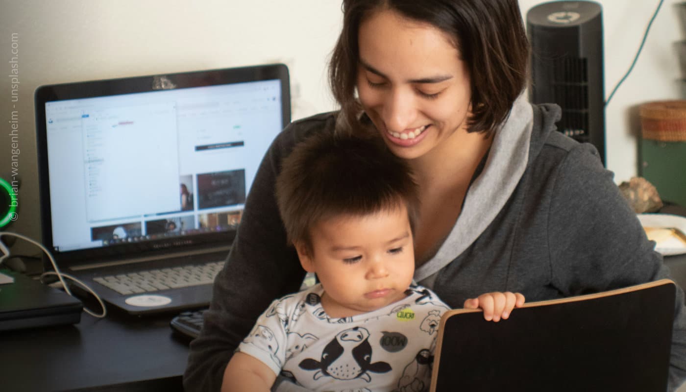 Frau mit Baby vor Laptop